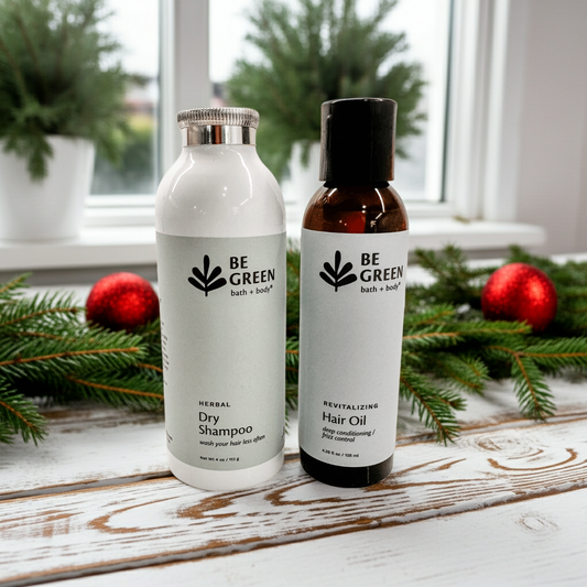 Two bottles of 'Be Green' products on a wooden surface with Christmas decorations in the background.
