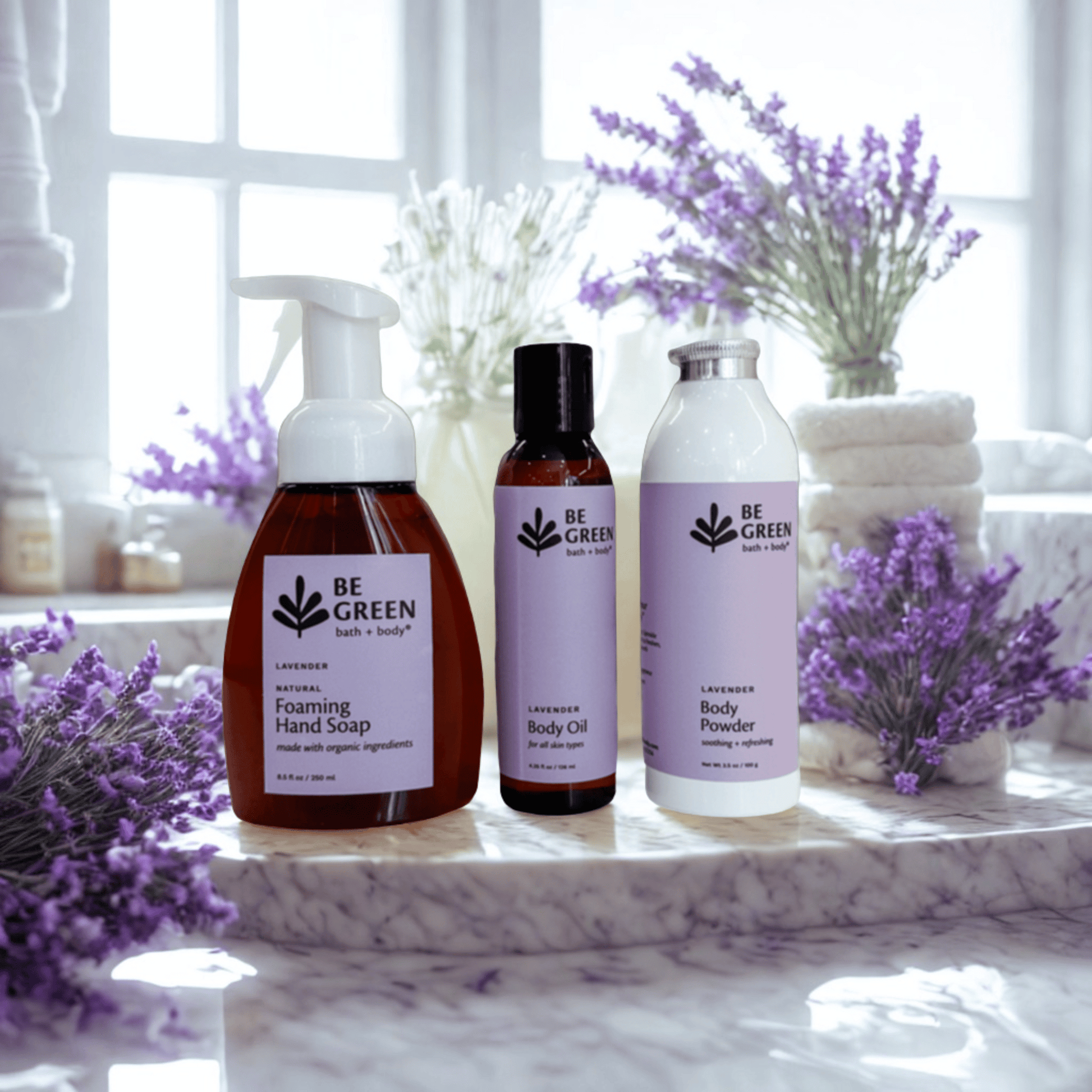 Set of 'Be Green' bath and body products with lavender flowers on a marble surface.