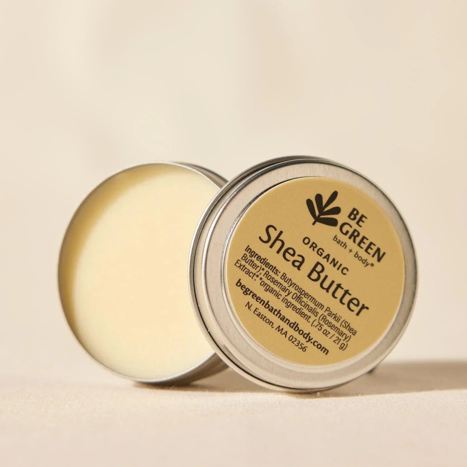 Open tin jar of organic unrefined shea butter.