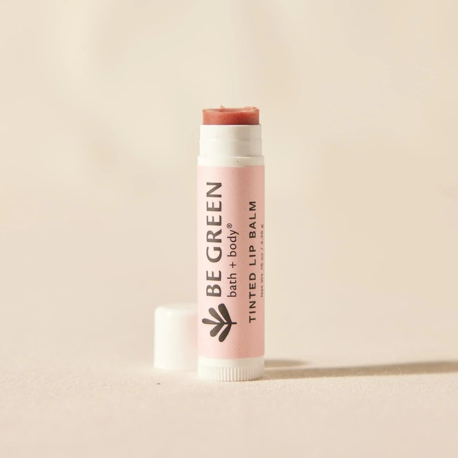 All natural beeswax tinted lip balm with cap off.