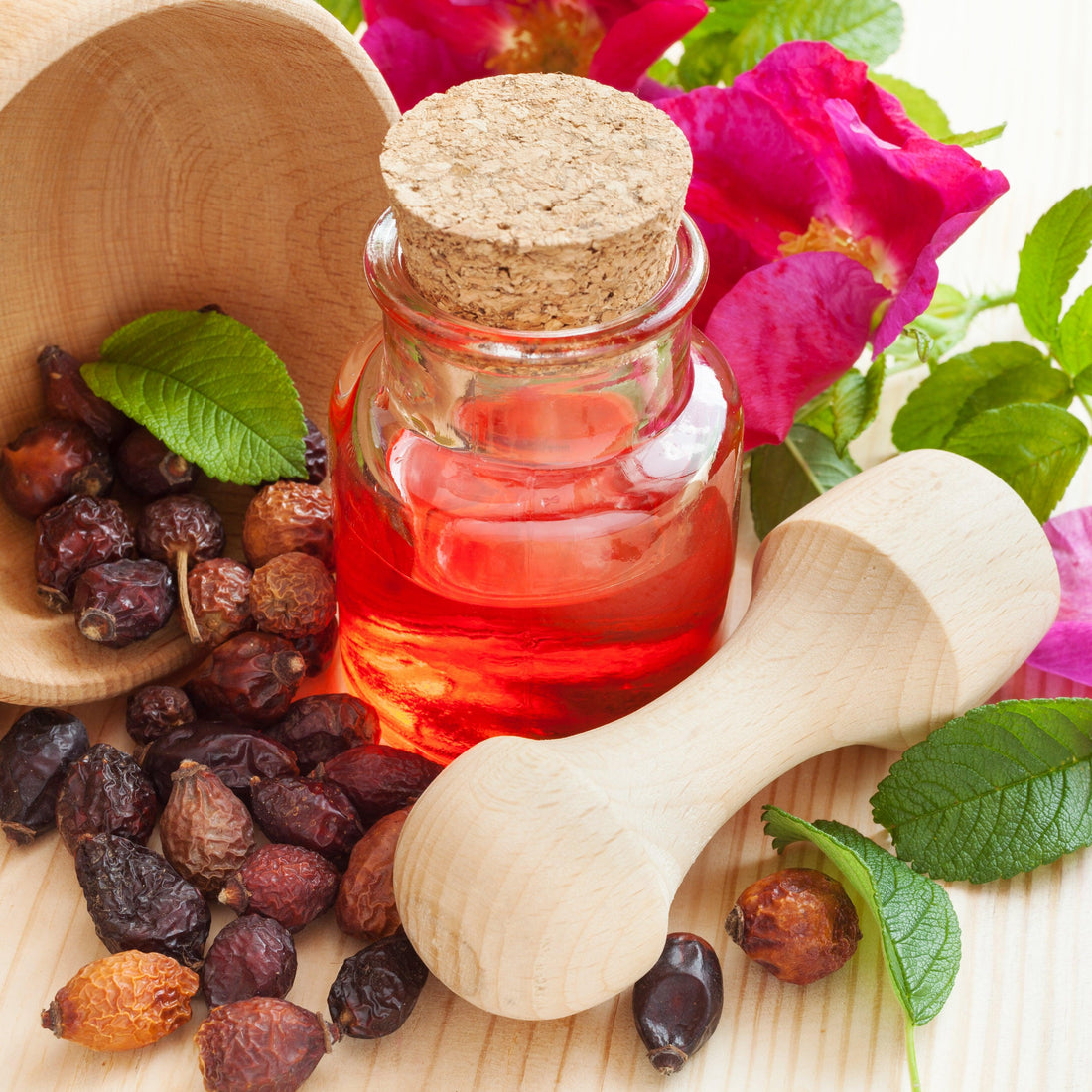 Picture of rosehip oil in clear bottle with dried rosehips 