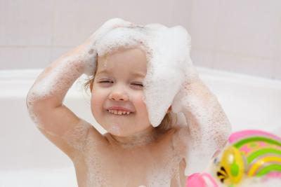 toddler in tub with lots of soap bubbles