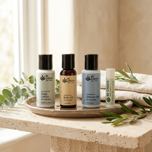 Four BE GREEN body care products arranged on a round tray on a stone surface, with eucalyptus leaves and a folded towel in a softly lit indoor setting.