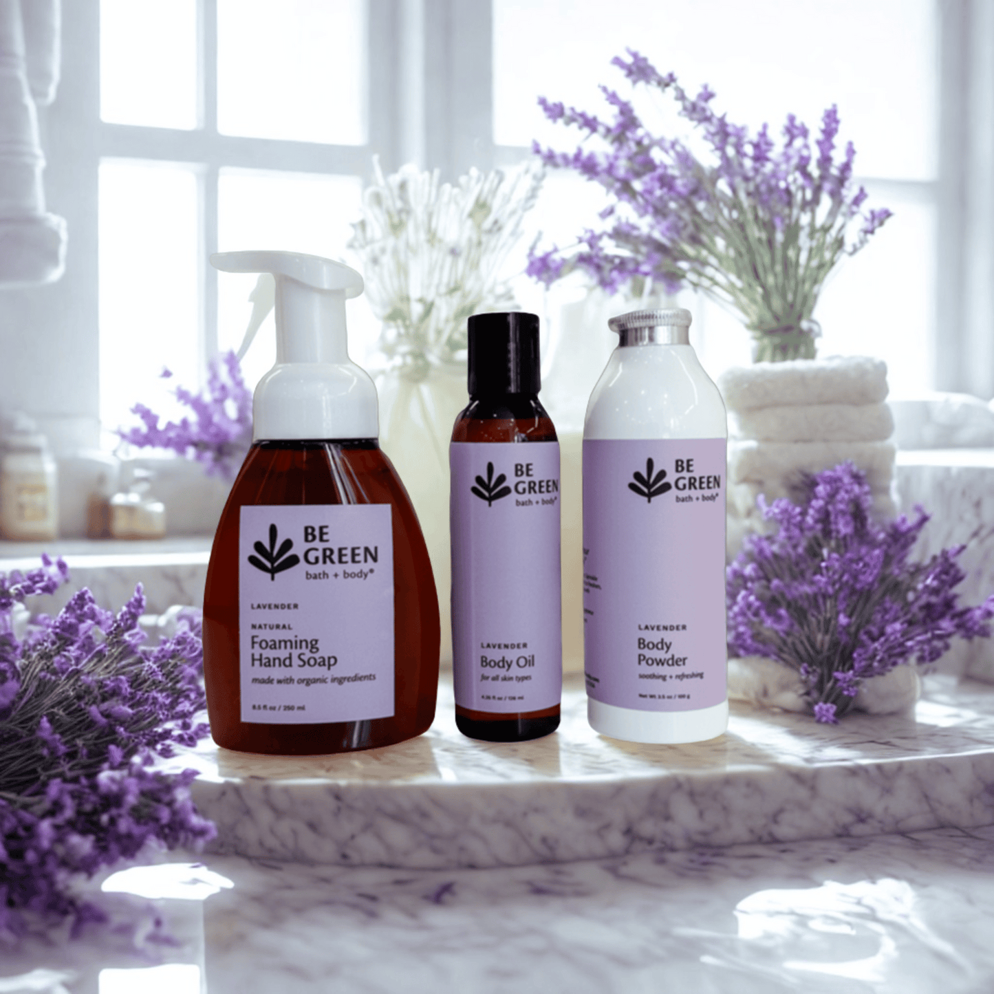 Set of 'Be Green' bath and body products with lavender flowers on a marble surface.