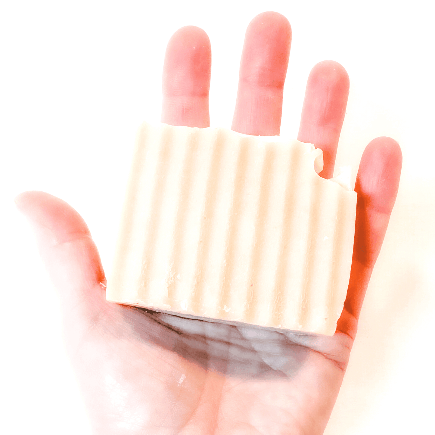 raw goat milk soap bar in hand to show size